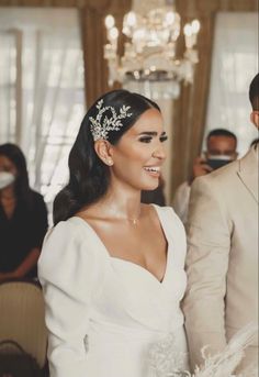 a woman in a white dress is walking down the aisle