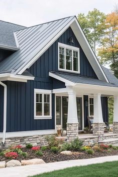 a house with blue siding and white trim on the front door, windows, and porch