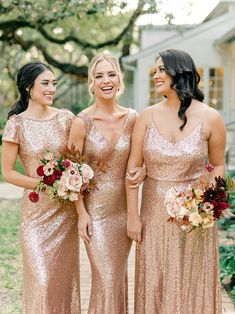 three bridesmaids in gold sequin gowns and bouquets smiling at each other