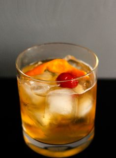 a close up of a drink in a glass with ice and fruit on the rim