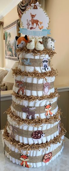 a diaper cake made to look like a baby's first birthday tree with animals on it