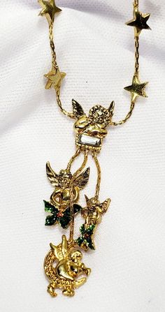 This is a such a pretty necklace. It has three dangling cherub, pixie charms and two have green enamel flowers. The one at the top has one single rhinestone.  The chain is adorned with a few stars and this is adjustable. This could possible be a Kirks Folly piece and the hang tag fell off. The clasp works and more modern of a piece than true vintage. Overall in good condition. See all photos for wear and sizing.  **PAYMENT IS DUE WITHIN 24 Hours OF THE AUCTIONS END** If you need more time, PLEASE CONTACT ME. If you have any problems with the items please let me know before leaving feed back and I will gladly remedy ANY situation. **Thank you!!!** Cherub Angel, Kirks Folly, Antique Jewelry Necklace, Pretty Necklace, Gold Moon, Pretty Necklaces, Enamel Flower, Green Enamel, Star Necklace