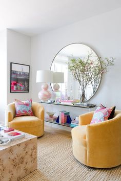 a living room filled with furniture and a round mirror