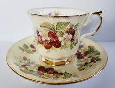 a cup and saucer decorated with strawberries