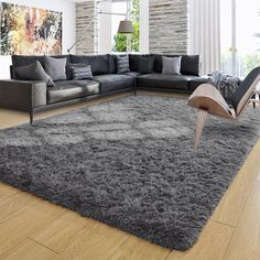 a living room with a large gray rug on the floor