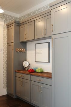 a kitchen with gray cabinets and wooden counter tops