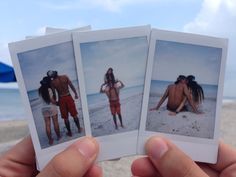 three polaroids are held up in front of the camera, with two people on the beach behind them