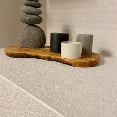 some rocks are stacked on top of each other and one candle is next to it