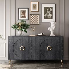 a sideboard with two doors and some pictures on the wall