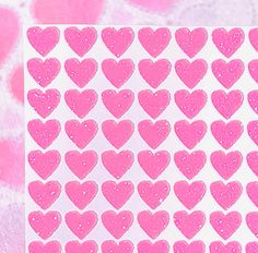 pink heart stickers on white paper with polka dot pattern in the middle and bottom