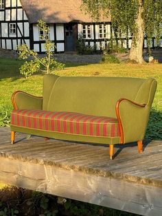 a green couch sitting on top of a wooden platform