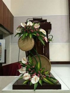 two baskets with flowers are on top of each other in the middle of a room