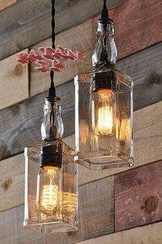 two hanging lights made out of glass jars on a wooden wall with wood planks in the background