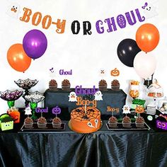 a table topped with lots of halloween treats and balloons in front of a sign that says booy or ghoul