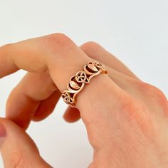 a person wearing a gold ring with hearts on it