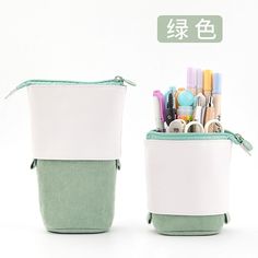 two green and white containers with pens, markers, scissors and pencils in them