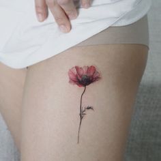 a woman's thigh with a flower tattoo on it