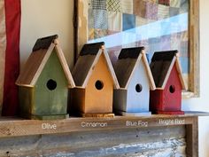 colorful birdhouses are lined up on a mantel