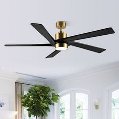 a ceiling fan in a living room with white walls and wood flooring on the other side