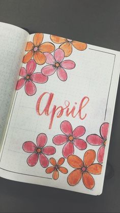 an open notebook with flowers and the word april written on it