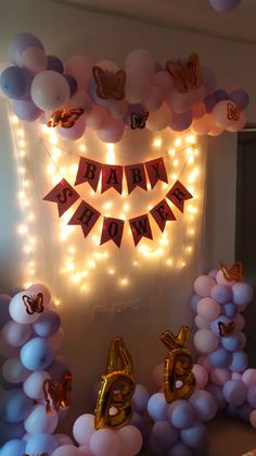 balloons and streamers are arranged in front of a birthday banner