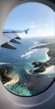 an airplane window looking out at the ocean and landforms in the water from above