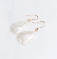 "Flattering on everyone, these beautiful earrings are so lightweight and eye catching. They feature a teardrop shaped mother of pearl with lots of pearly iridescence. The teardrop is approximately 1\" from top to bottom and dangles from a 14kt gold fill hand forged french ear wire." Pearl Drop Earrings In Mother Of Pearl, Mother Of Pearl Dangle Pearl Earrings, Elegant Teardrop Mother Of Pearl Earrings, Pearl Drop Mother Of Pearl Earrings, High Luster Teardrop Pearl Earrings, White Teardrop Mother Of Pearl Jewelry, Iridescent Pearl Drop Dangle Earrings, Teardrop Mother Of Pearl Wedding Earrings, Teardrop Mother Of Pearl Ear Wire Jewelry