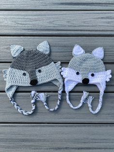 two crocheted hats with animals on them, one is grey and the other is white