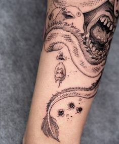 a person with a tattoo on their arm that has an image of a dragon and other animals