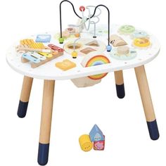 a child's play table with wooden legs and various toys on the table top