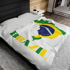 a bed with a white comforter that has the brazil flag and map on it