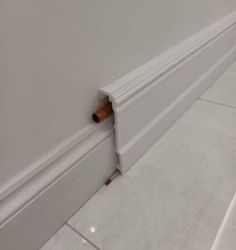 the corner of a room with a white wall and door handle on it's side