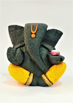 an elephant statue sitting on top of a yellow pillow