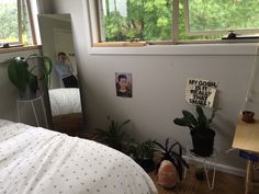 a bedroom with plants and pictures on the wall