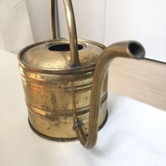 an old brass tea kettle with a handle