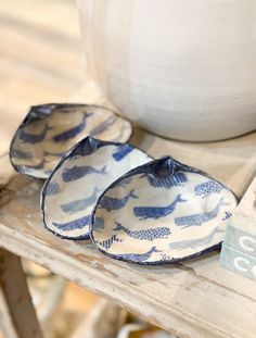 three blue and white plates sitting on top of a wooden table