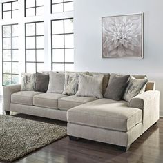 a living room scene with focus on the sectional sofa and rug in the foreground