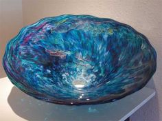 a glass bowl sitting on top of a white counter next to a wall and floor