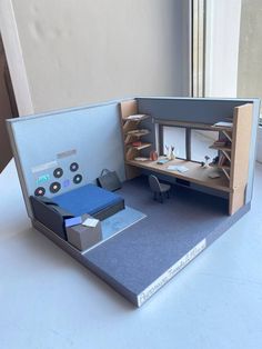 an office cubicle is made out of cardboard and has several items on the desk