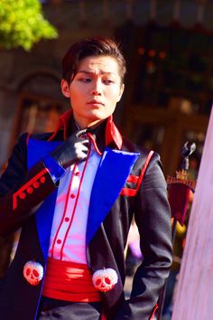 a young man dressed in costume standing next to a pole