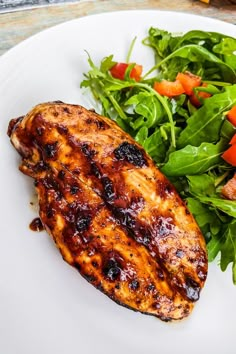 a white plate topped with chicken and salad