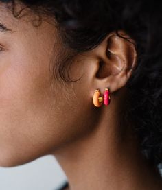 a close up of a person wearing ear rings with colorful beads on their ears,