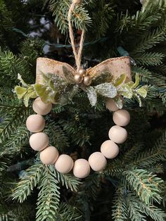 a christmas ornament hanging from the top of a tree with a bow on it