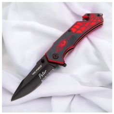 a red and black knife on white fabric