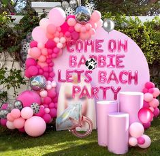 some pink balloons and other decorations on the grass in front of a sign that says come on babe let's bach party