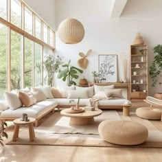 a living room filled with lots of furniture and plants on the wall next to large windows