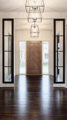 an empty room with wooden floors and glass doors on either side of the entrance door