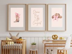 a baby's room with three framed pictures on the wall