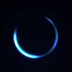 a blue ring is seen in the dark with its light reflecting off it's side