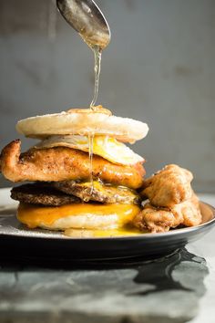 an egg sandwich is being drizzled with syrup